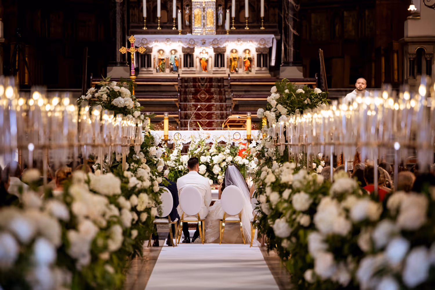 Wedding in Piekary Śląskie (Poland). Young couple sitting in the middle of the church before the altar.