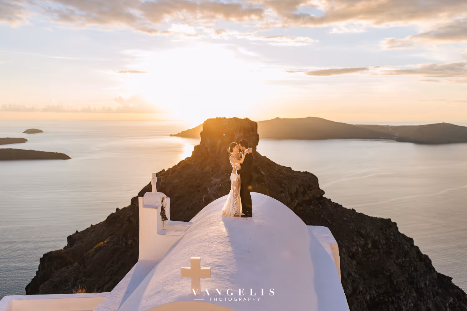 Wedding in Greece, Santorini. Young couple standing on the roof of a building, looking into each other's eyes.