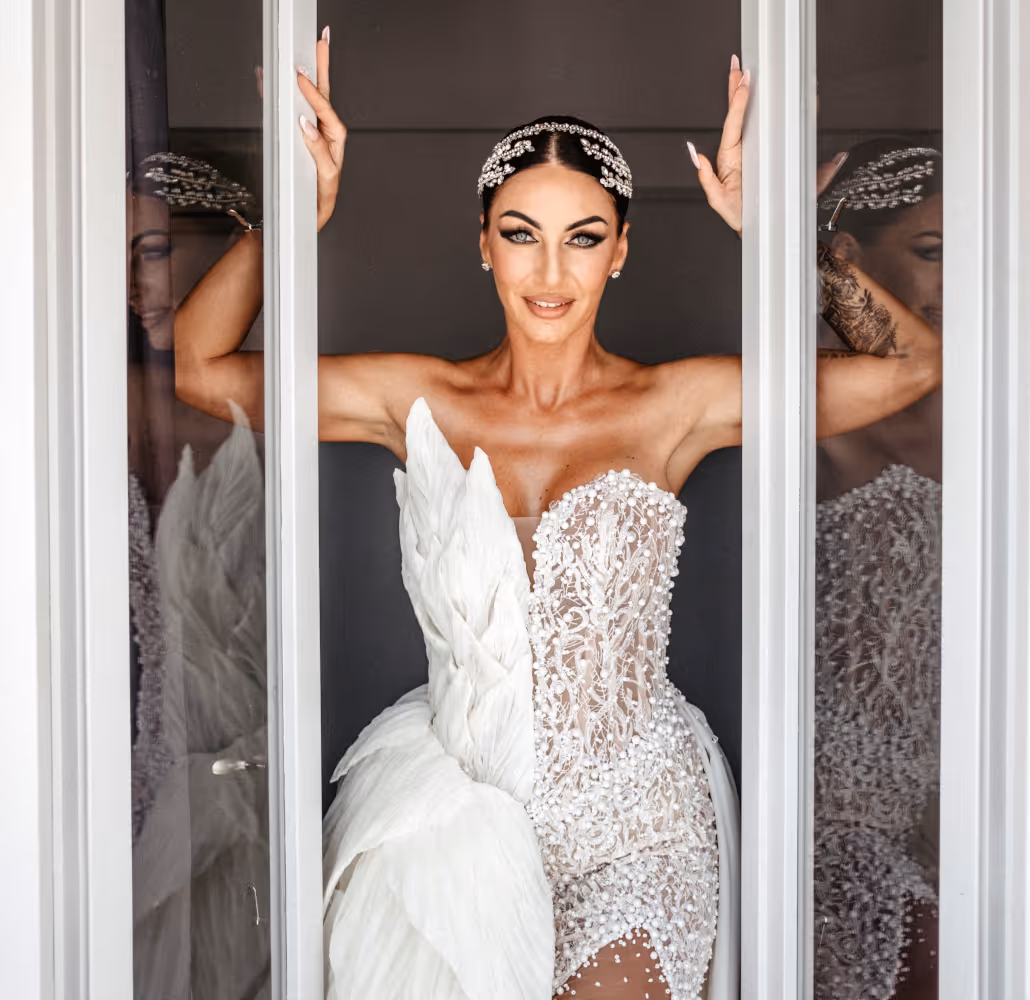 Wedding in Greece. Santorini. A shot of the bride in a wedding dress opening a window