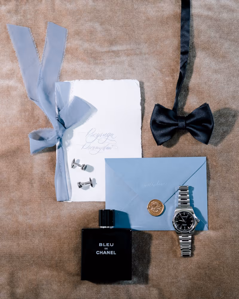 Wedding in Italy. Lake Garda. A shot showing a watch, a bow tie, perfume, and cufflinks