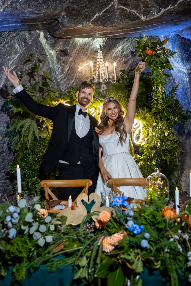 Wedding at the Wieliczka Salt Mine. Poland. Photo of the bride and groom in the wedding hall cheering for guests.