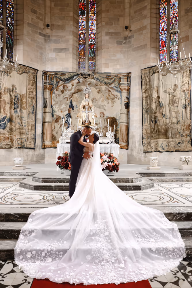 Wedding in Spain in Peralada. Young couple kissing in the church.